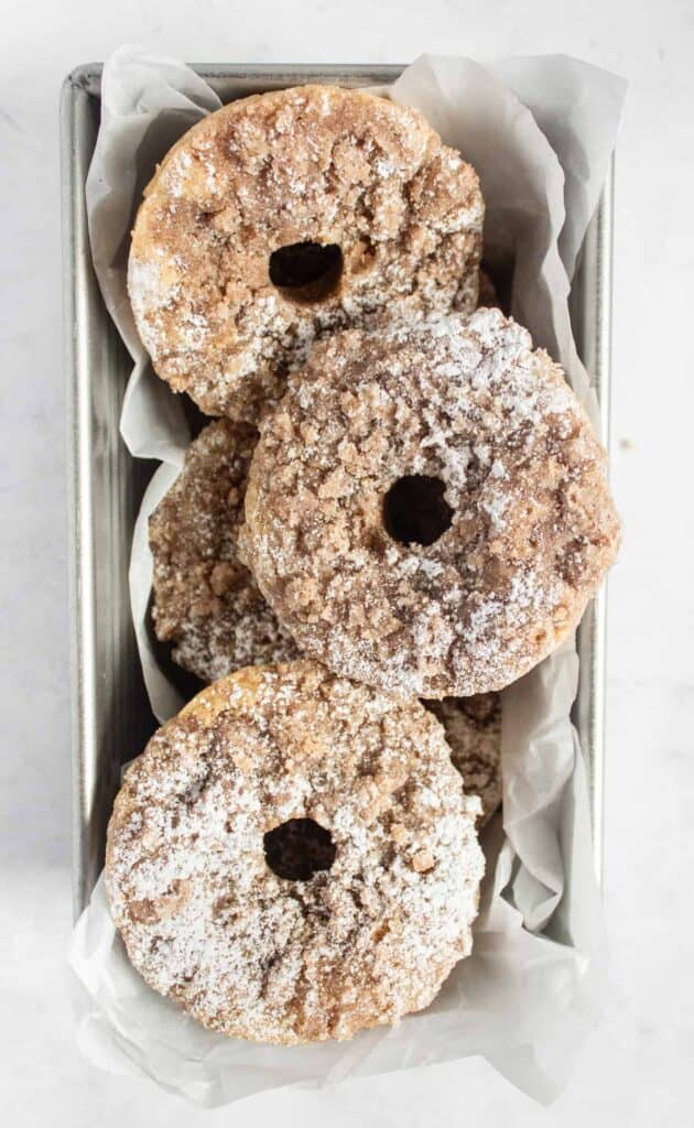 overhead shot of a group of baked crumb cake donuts. the topping looks delicious!