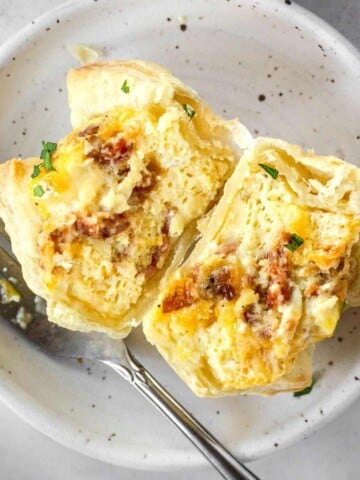 puff pastry breakfast cup cut in half on a white plate