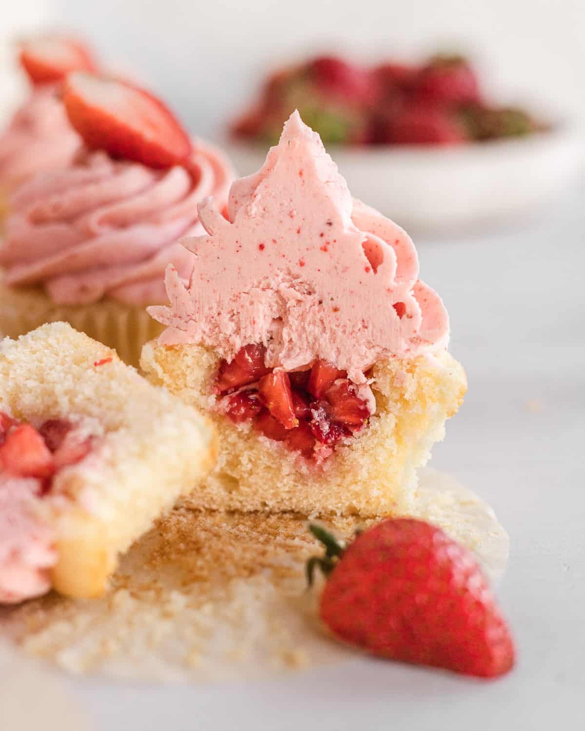 strawberry cupcake cut in half so you can see the filled insides with strawberries. 