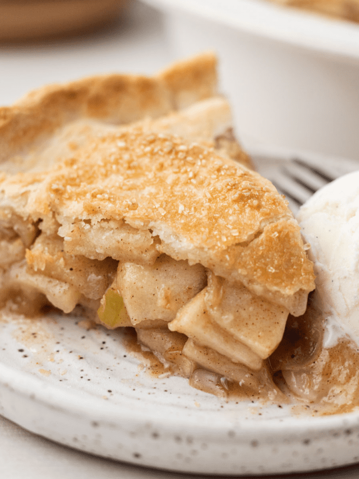 pie sitting on a white plate with a scoop of vanilla ice cream