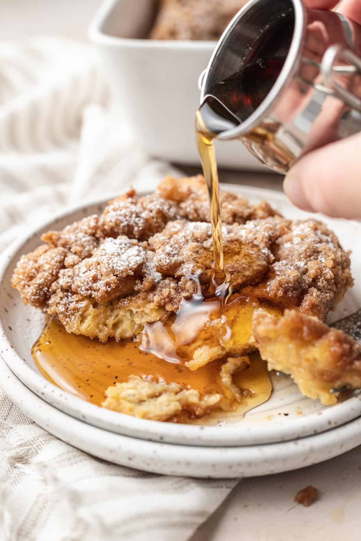 plate of french toast casserole with syrup being poured on top