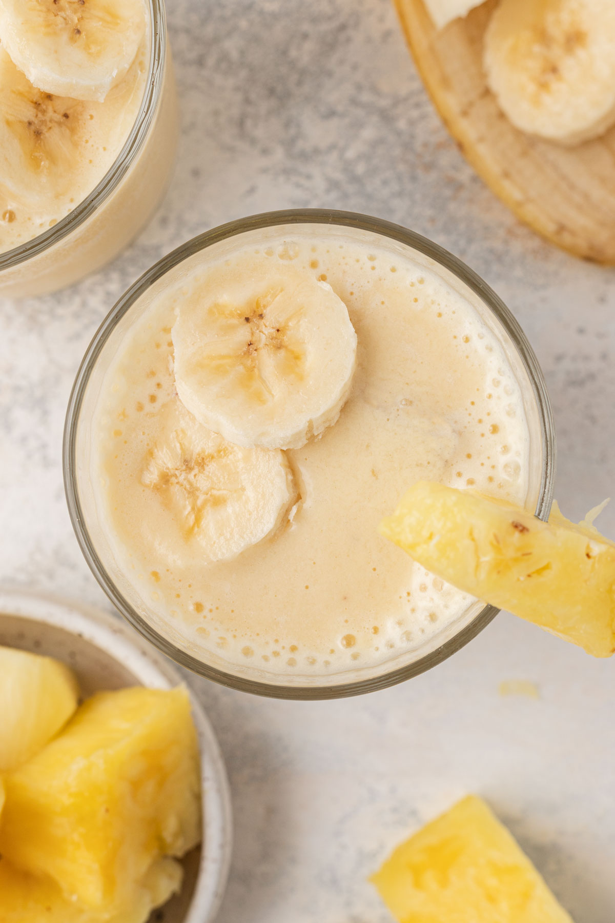 overhead look on the smoothie with sliced banana and pineapple on top