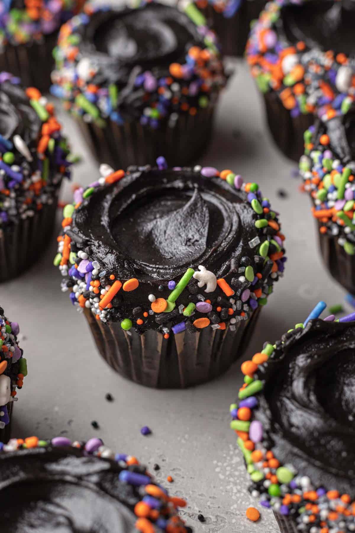 Close up shot of black velvet cupcake  on sheet with entire batch of black velvet cupcakes.