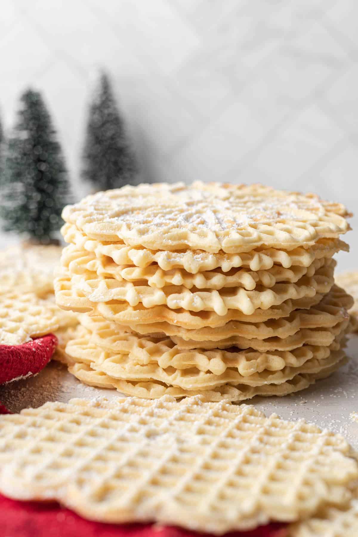 Stack of Pizzelle Cookies freshly dusted with powdered sugar.
