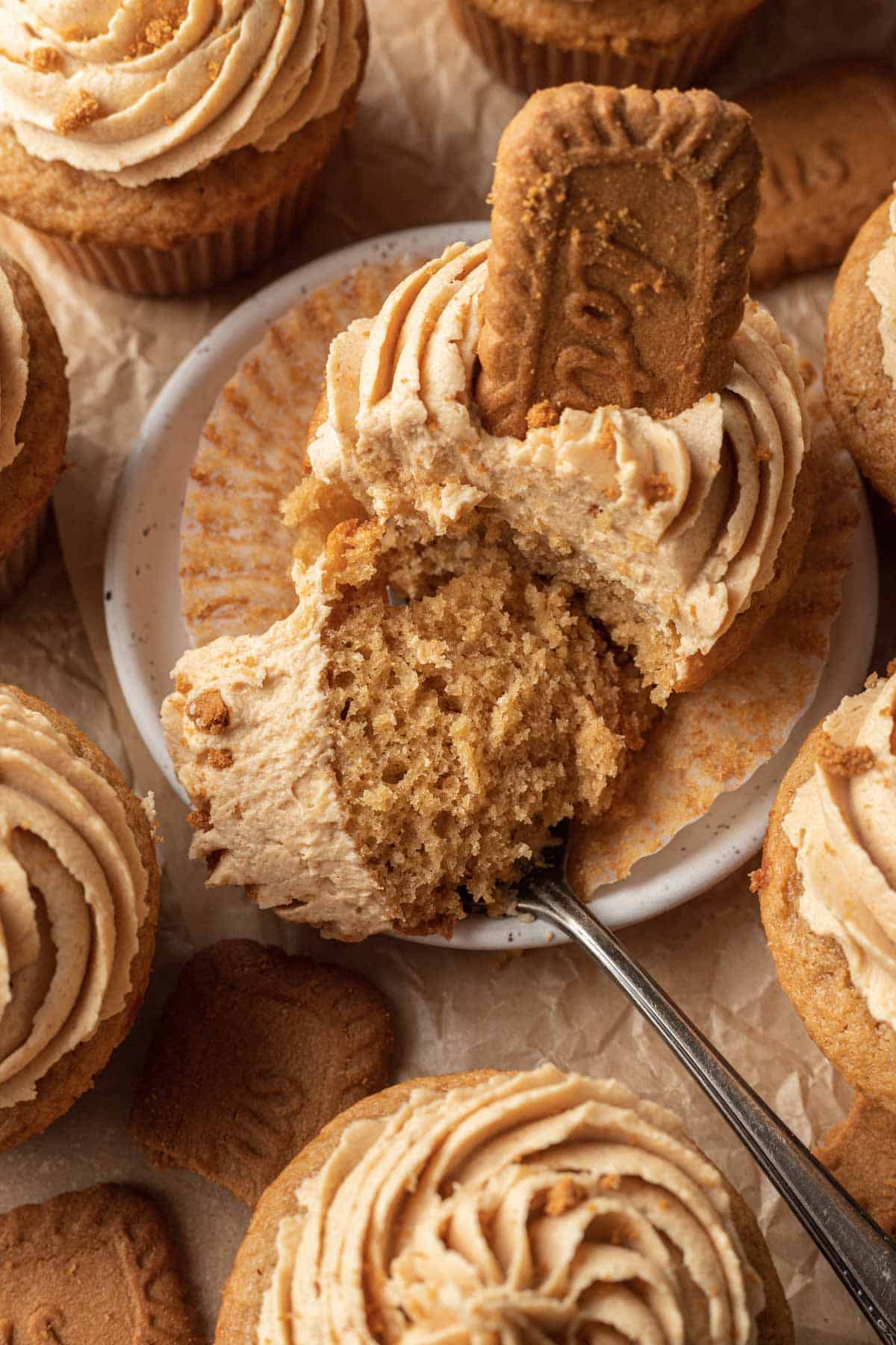 Close up of one Biscoff cupcake that has a bite sized amount placed on a fork ready to be eaten.