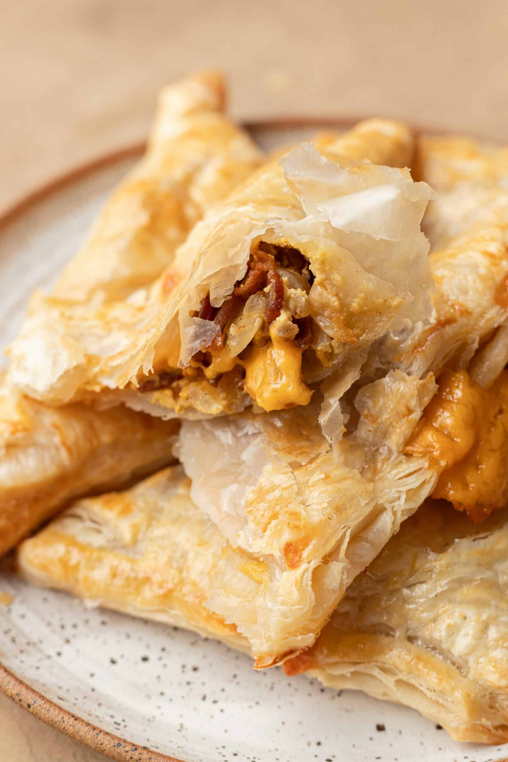 a bacon and cheese turnovers ripped in half so you can see the bacon and cheese gooey insides. 