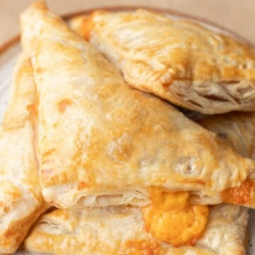bacon and cheese turnovers stacked on a plate