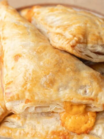 bacon and cheese turnovers stacked on a plate