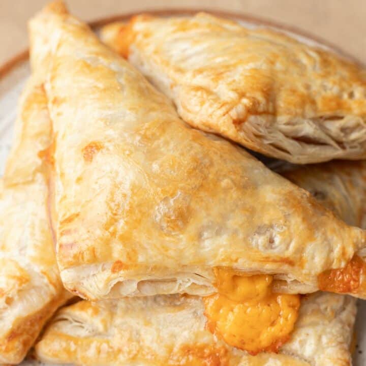 bacon and cheese turnovers stacked on a plate