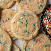 Fresh batch of confetti cookies on a sheet of parchment paper.