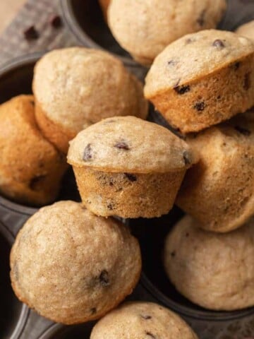 mini chocolate chip muffins stacked on top of one another in a muffin tin