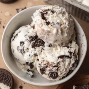 3 scoops of ice cream in a white dish with crushed oreo cookie pieces around it