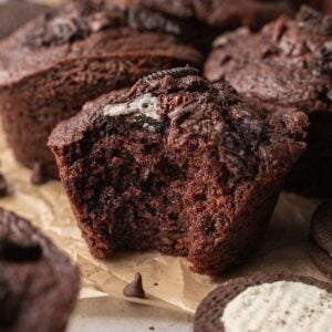 An oreo muffin with a bite taken out of it.