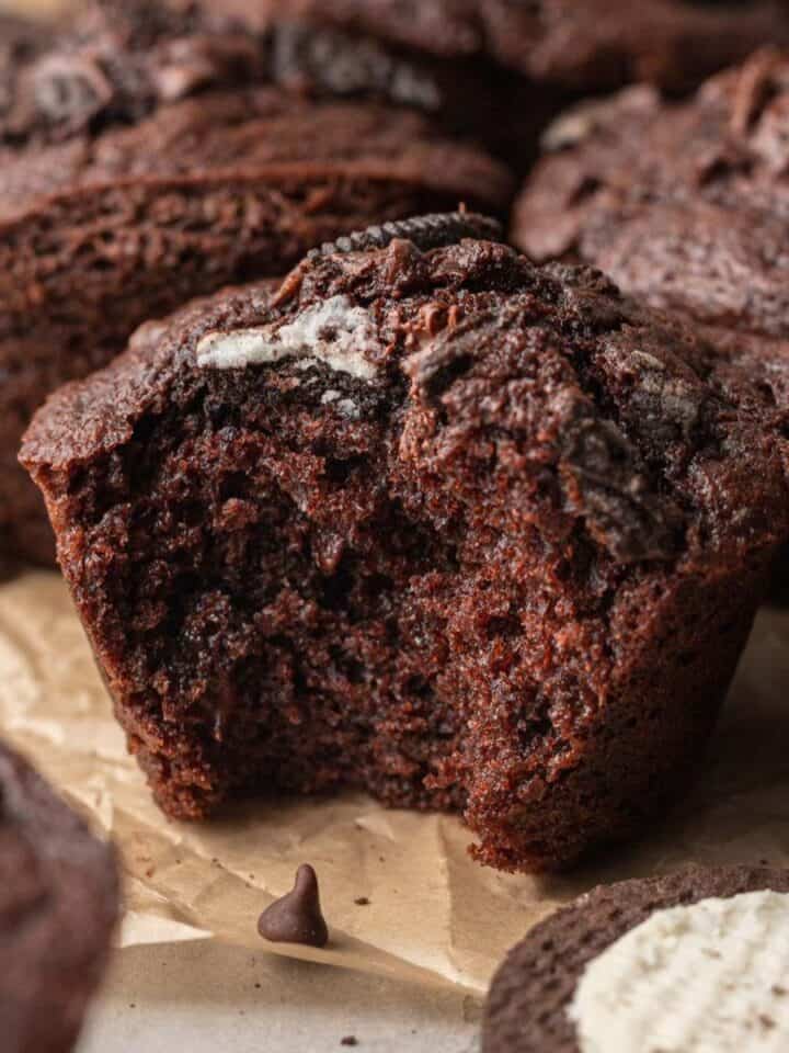 An oreo muffin with a bite taken out of it.
