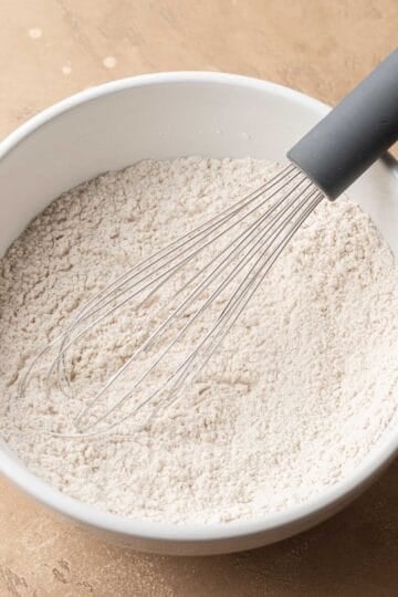 dry ingredients together in a white ceramic bowl with a metal whisk.