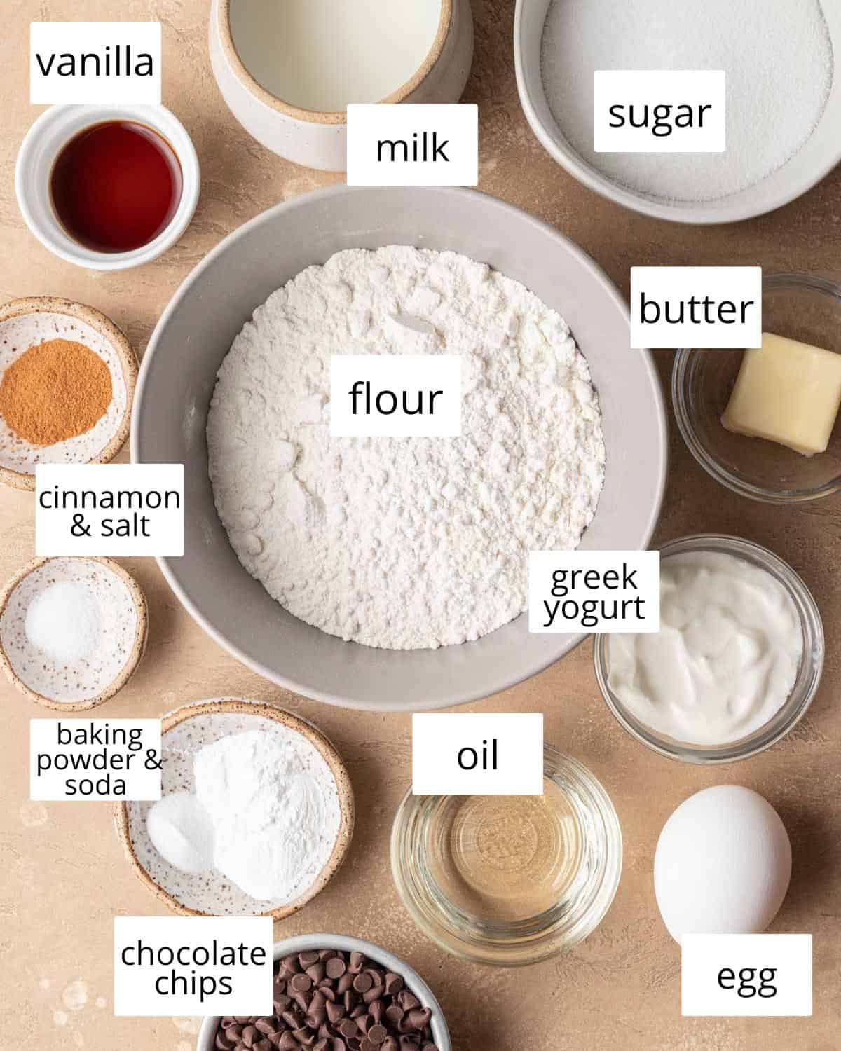 ingredients needed to make mini chocolate chip muffins laid out on a brown backdrop.