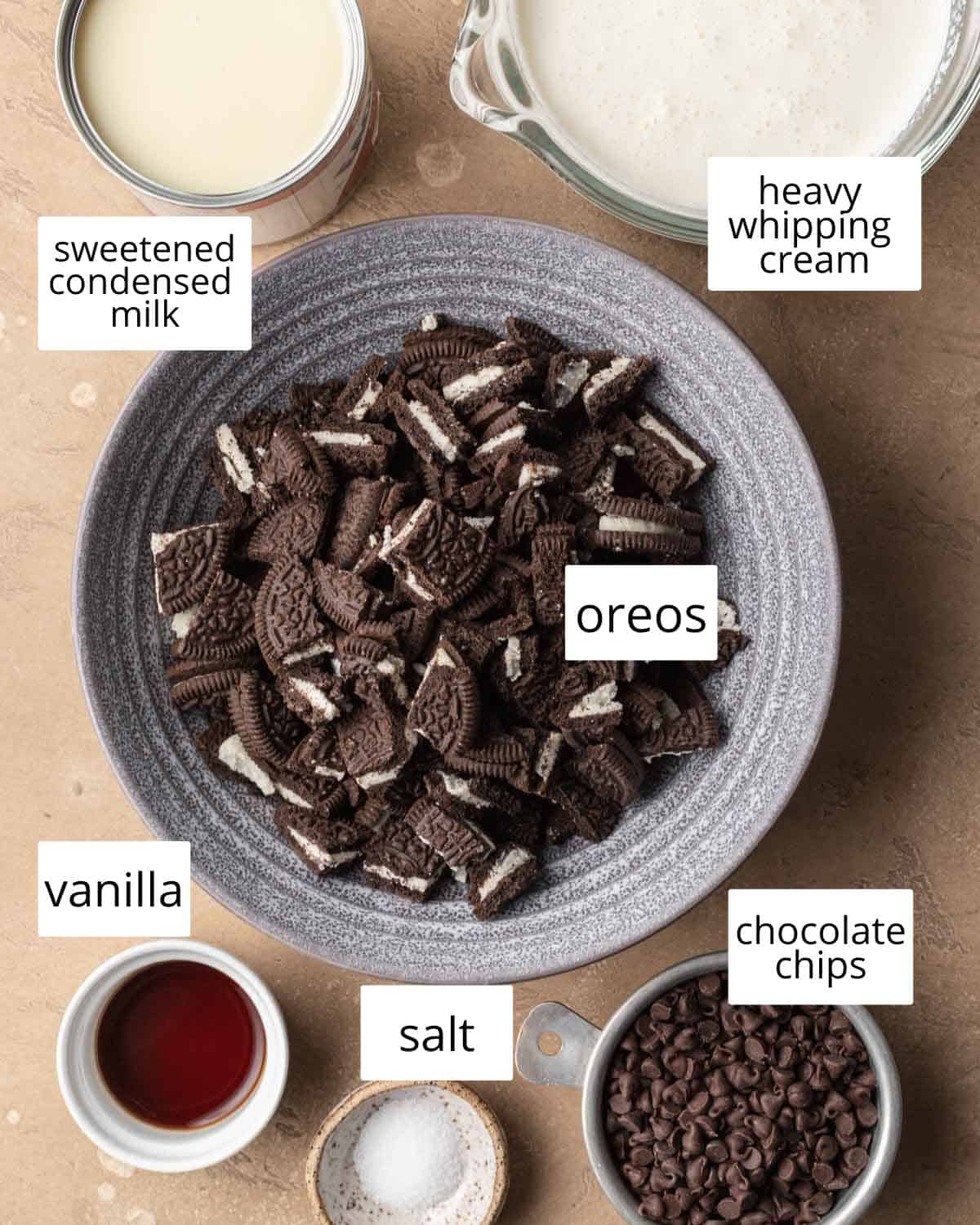 ingredients needed to oreo ice cream laid out on a brown backdrop.