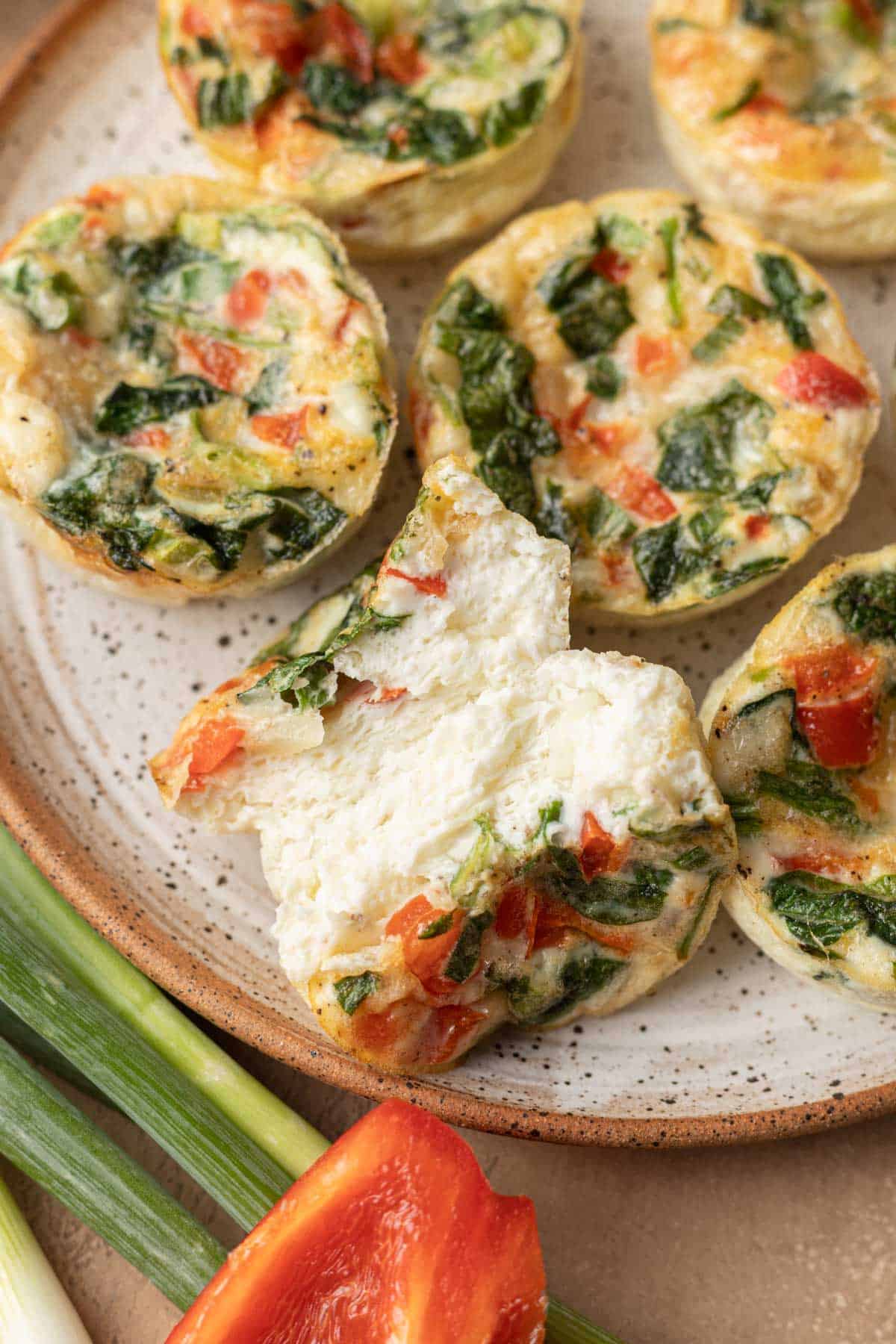 A birds eye view of egg white cups with one egg white cup that is cut in half.