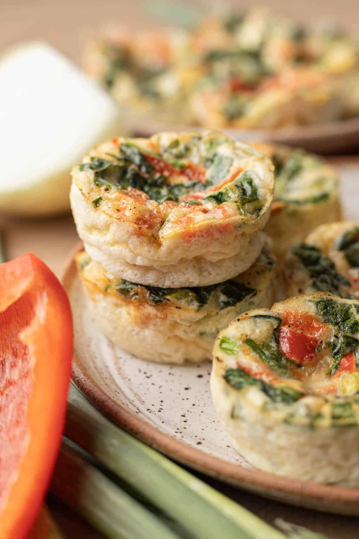 Freshly baked batch of egg white cups sitting on a plate ready to be eaten.