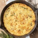 Fully baked asparagus feta frittata in a cast iron skillet.