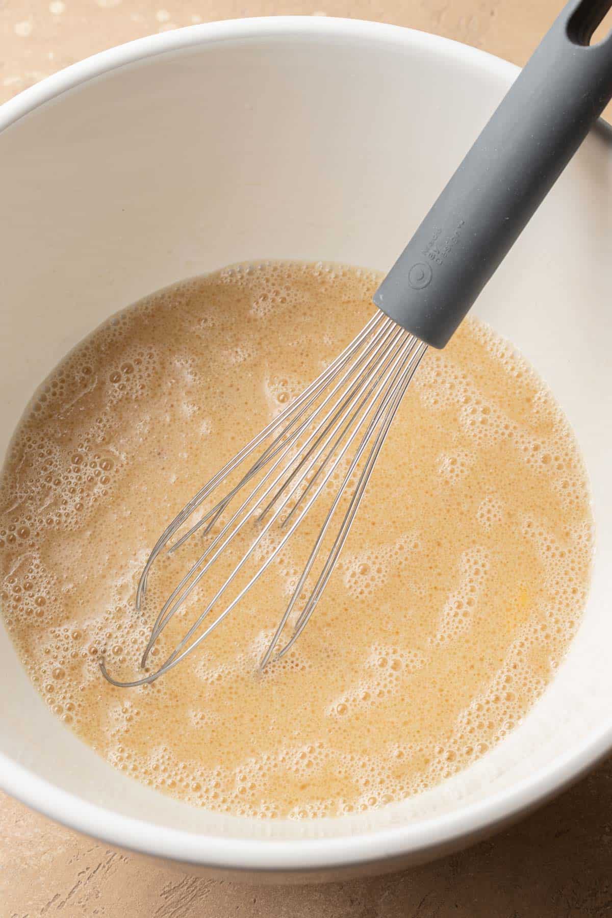 Wet ingredients in white glass mixing bowl.