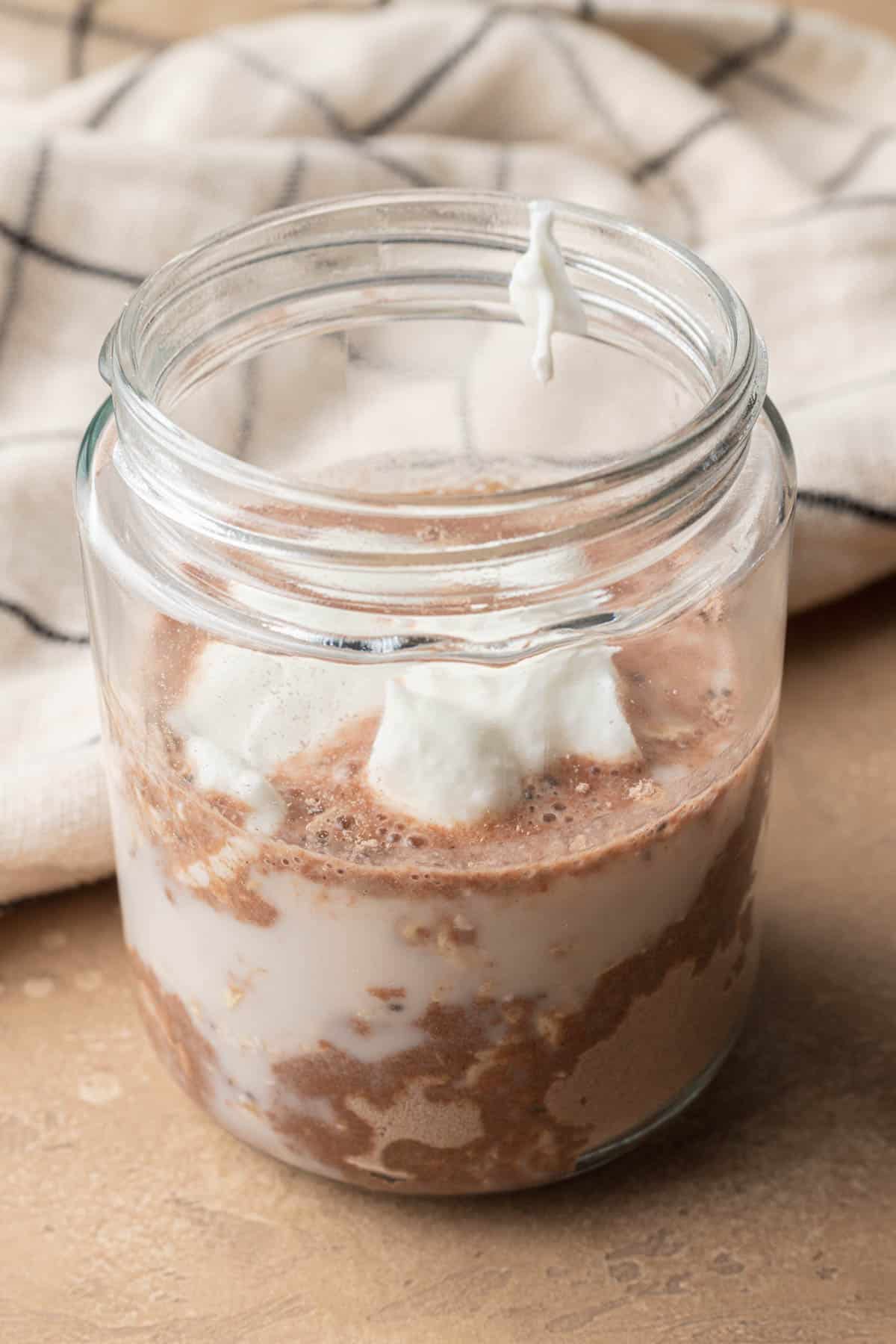 Mason Jar filled with chocolate protein overnight oats.
