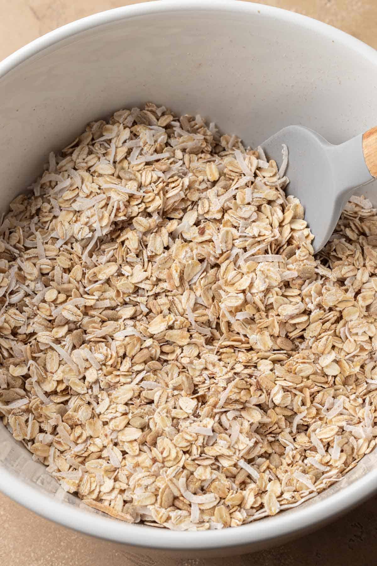 Dry ingredients for homemade granola in a white mixing bowl.