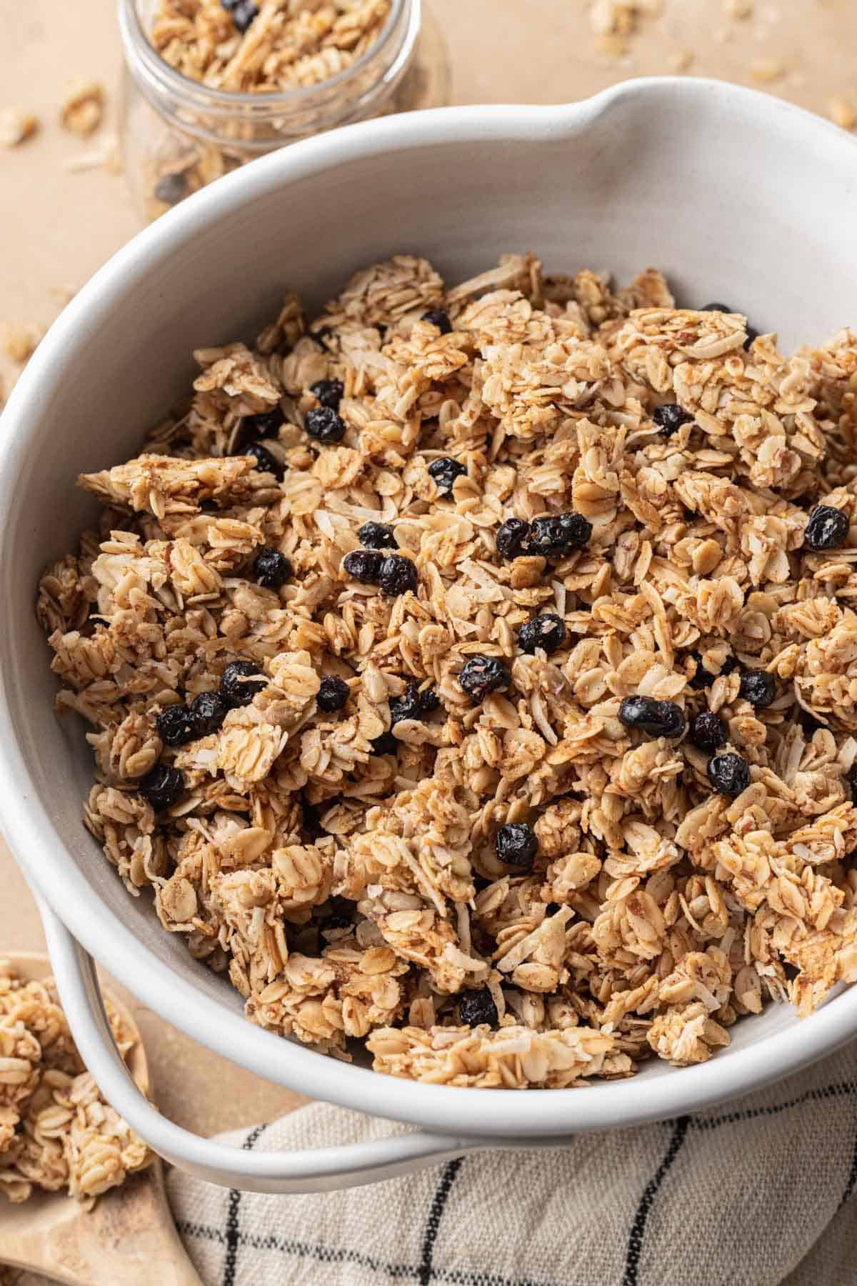 Homemade granola that is ready to eat served in a white bowl.