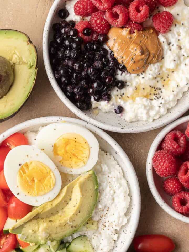 overhead view of both savory and sweet cottage cheese bowls with extra toppings surrounding them