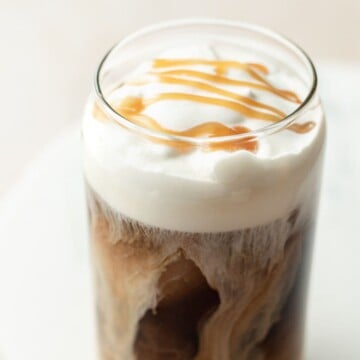Salted Caramel Cream Cold Brew in a glass cup with caramel drizzle on top.