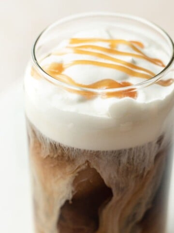Salted Caramel Cream Cold Brew in a glass cup with caramel drizzle on top.