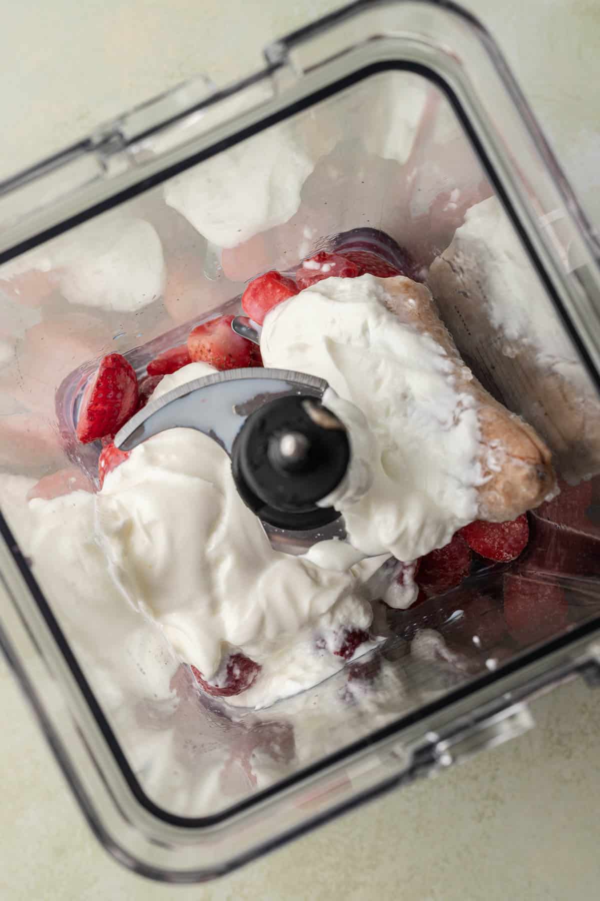 Ingredients for strawberry smoothie bowl in blender.