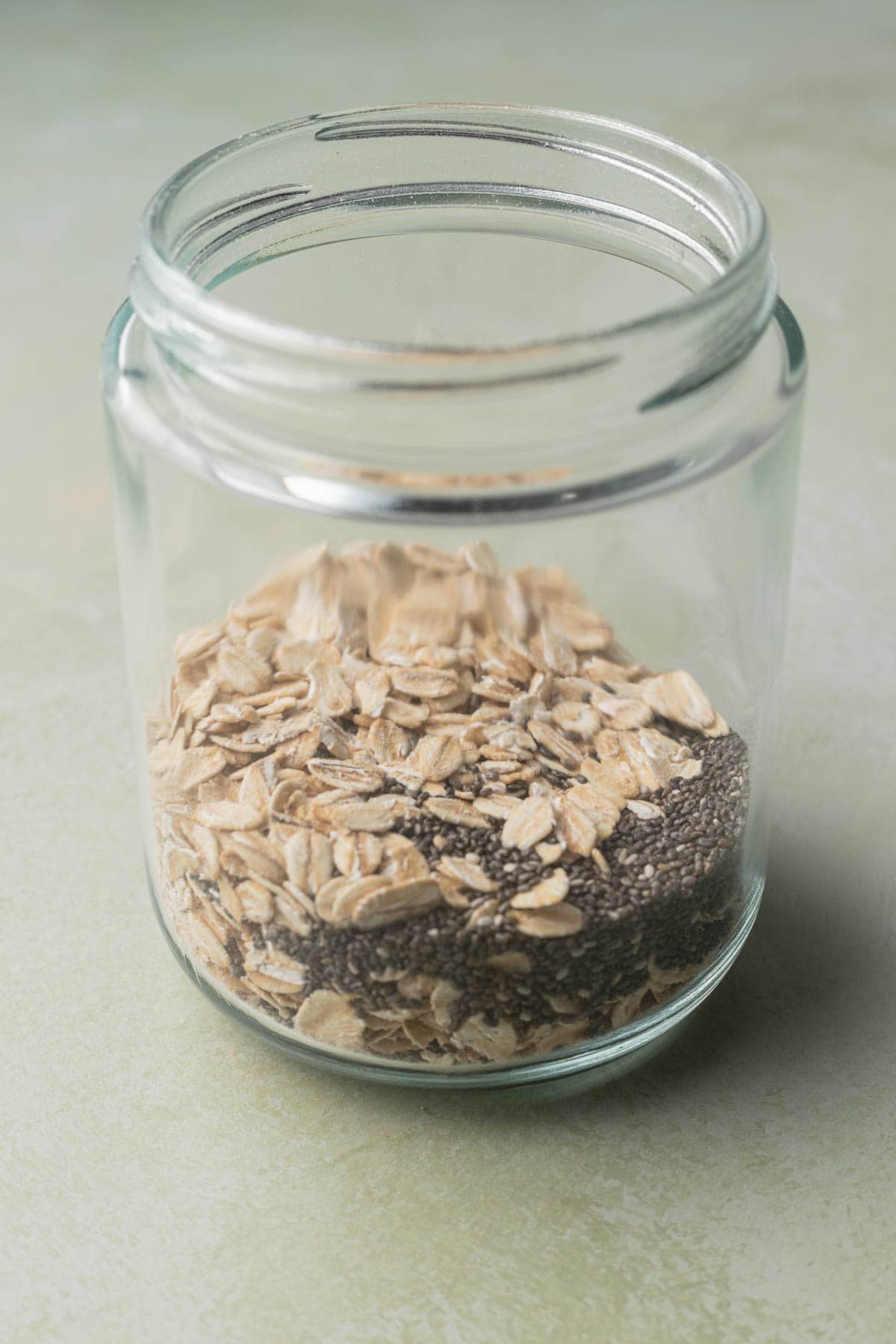 oats and chia seeds mixed together in a clear jar.