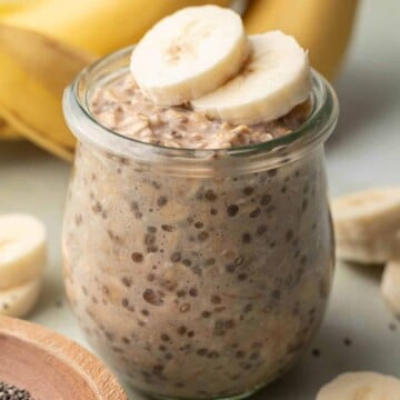 banana chia overnight oats in a glass jar with sliced bananas on top
