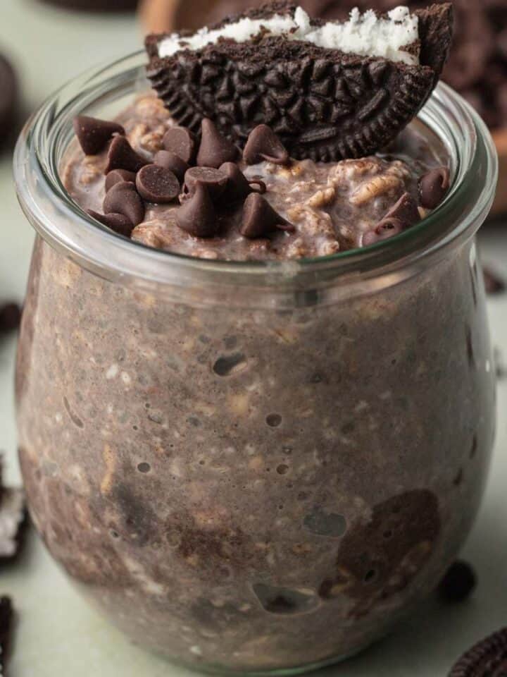 glass jar of oreo overnight oats with oreo on top.