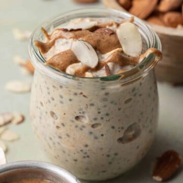 almond butter overnight oats in a glass jar with almond butter and sliced almonds on top