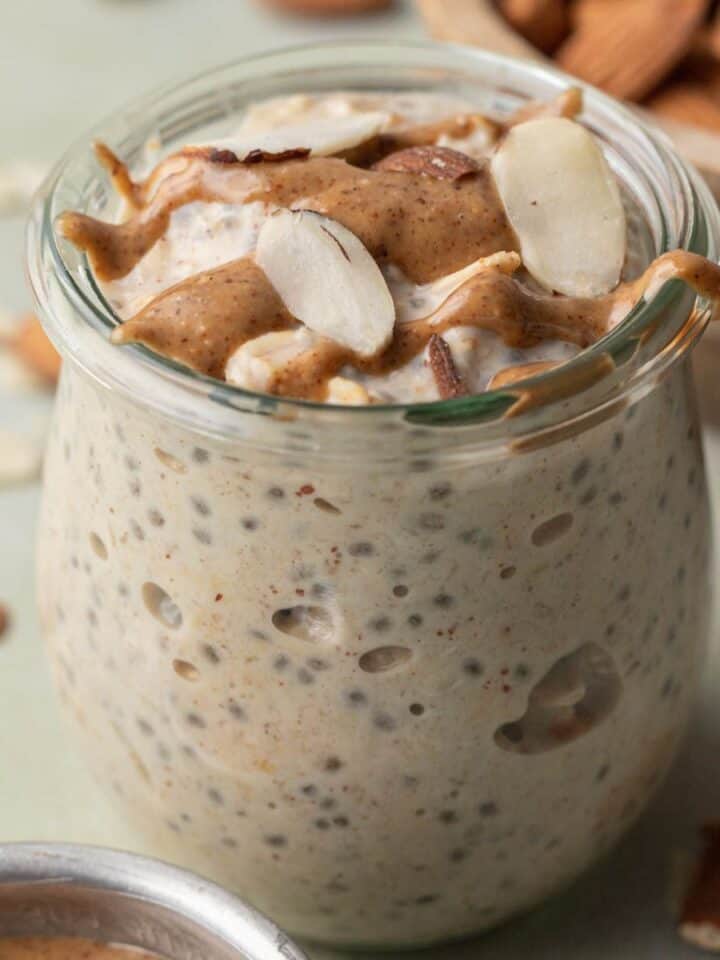 almond butter overnight oats in a glass jar with almond butter and sliced almonds on top