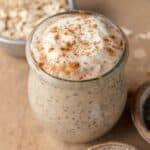 cinnamon roll overnight oats in a glass jar with cinnamon sprinkled on top.