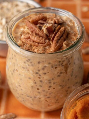 pumpkin pie overnight oats in a class jar with pecans on top