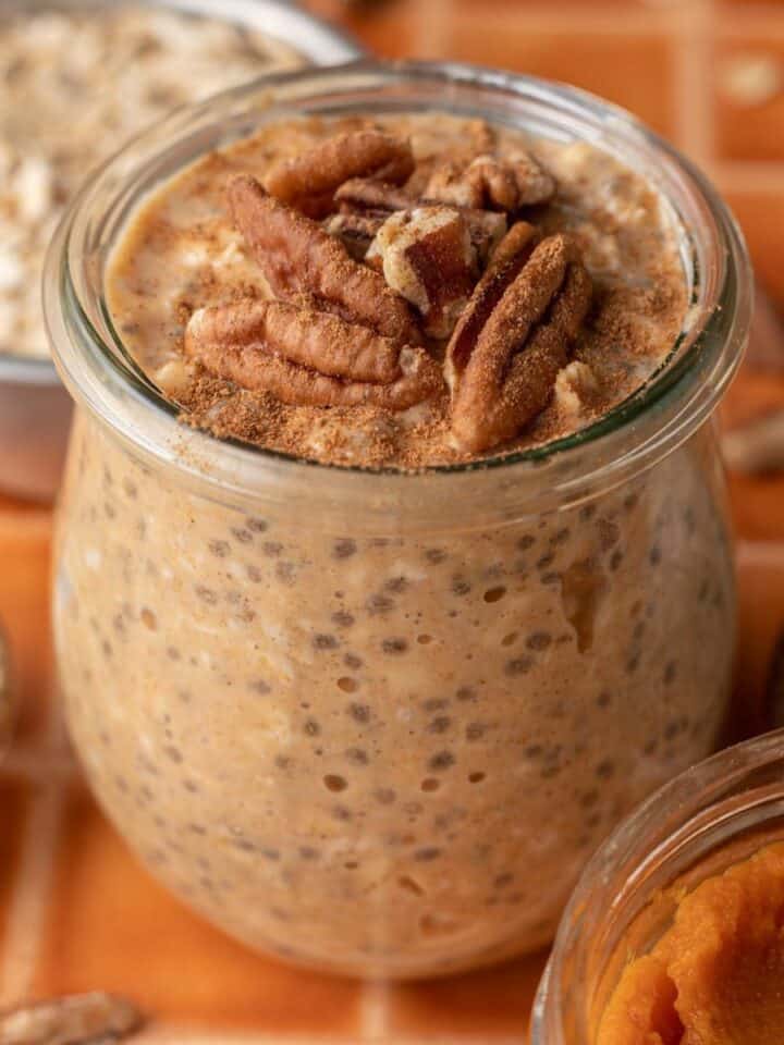 pumpkin pie overnight oats in a class jar with pecans on top