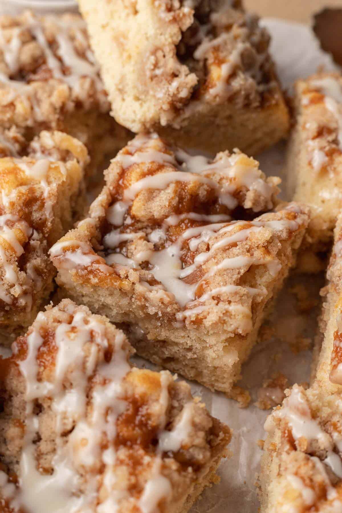 icing drizzled on top of a square slice of caramel coffee cake.