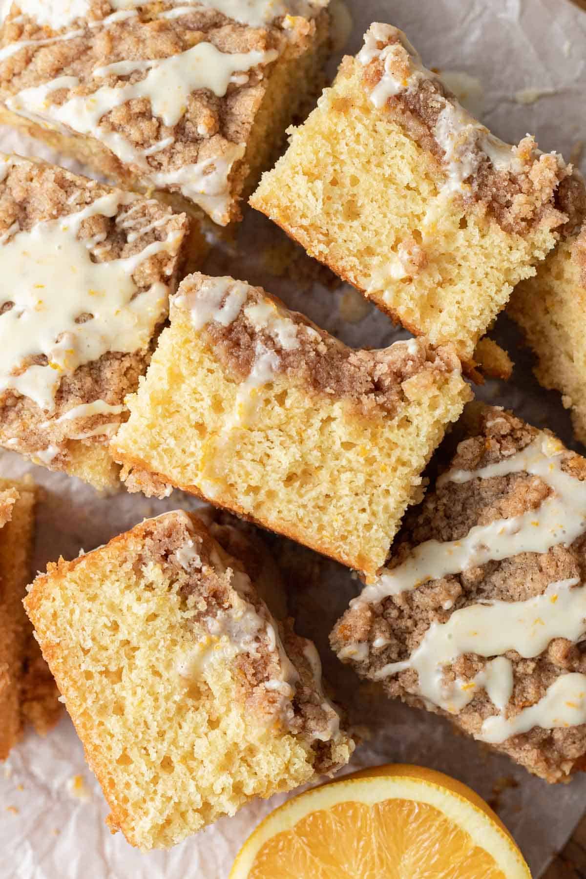overhead view of slices of orange coffee cake on their sides, topped with icing.