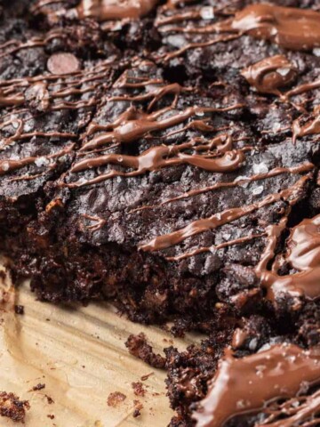 shot of sliced brownie baked oats topped with melted chocolate and flaky sea salt.