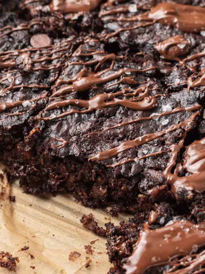 shot of sliced brownie baked oats topped with melted chocolate and flaky sea salt.