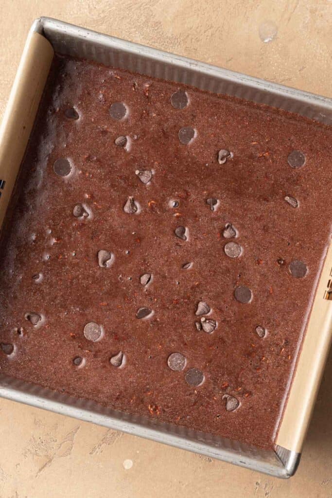 brownie baked oatmeal batter in the pan topped with extra chocolate chips before getting baked.