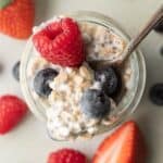 overhead view of cottage cheese overnight oats in a glass jar topped with berries