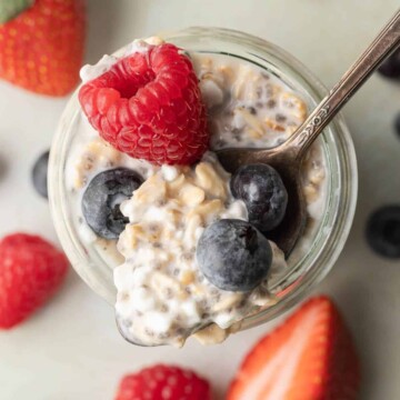 overhead view of cottage cheese overnight oats in a glass jar topped with berries