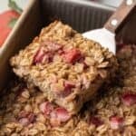 a piece of strawberry baked oats being taken from pan