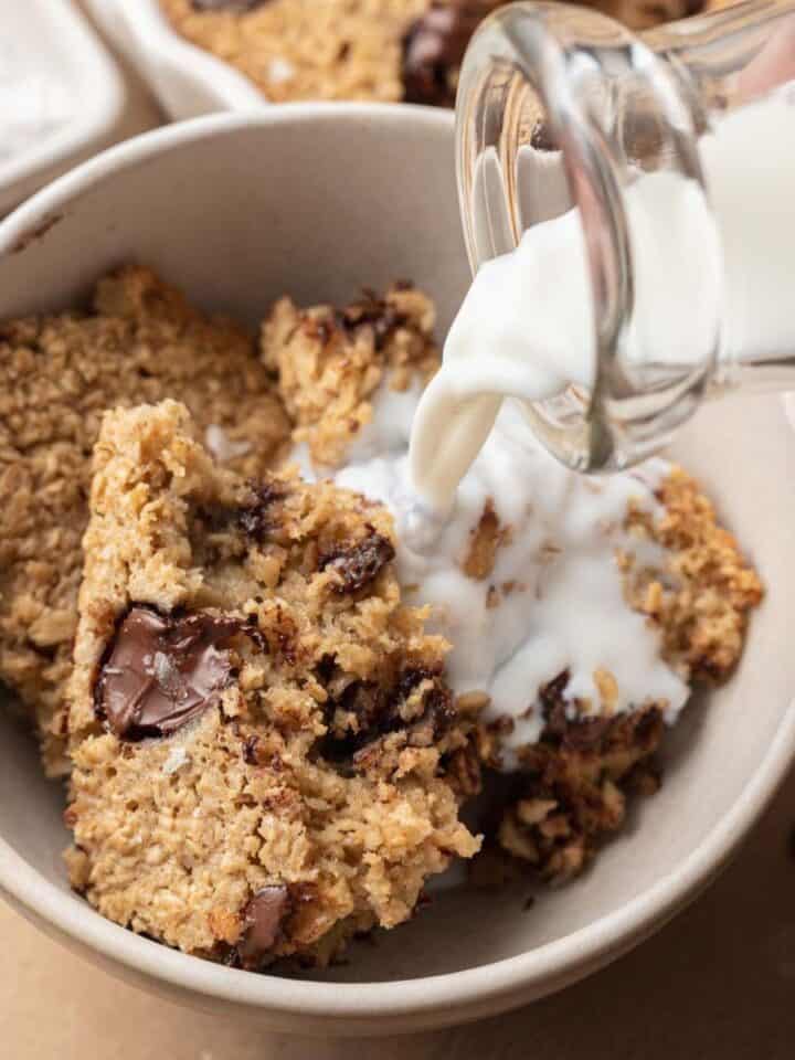 milk being poured into a bowl of chocolate chip cookie baked oatmeal.
