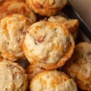 Close-up of savory cheese and bacon muffins stacked together on a tray.